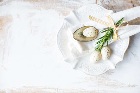 Festive table setting for Easter dinner on wooden rustic table