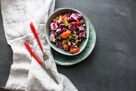 Healthy food concept with  fresh organic vegetables as a ingredients for salads on dark wooden table