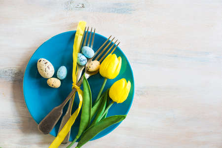 Festive table setting for Easter dinner on wooden rustic tableの写真素材