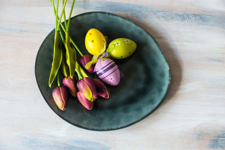 Festive table setting for Easter dinner on wooden rustic table