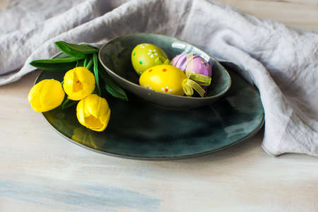 Festive table setting for Easter dinner on wooden rustic tableの写真素材
