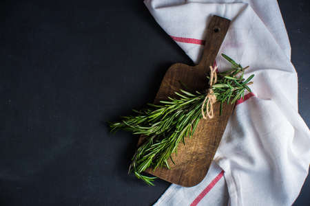 Different spices like a rosemary herb, bay leaf, garlic, pepper and salt on a wooden table as a cooking conceptの写真素材