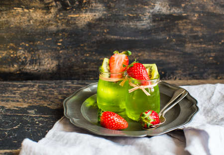 Jelly kiwi and strawberry desset on rustic table with copyspace