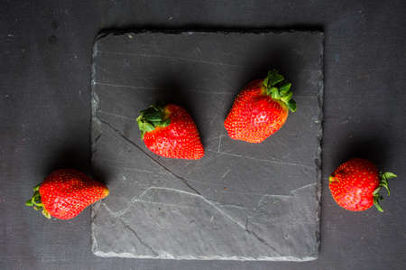 Fresh ripe organic strawberry fruits on dark wooden backgroundの写真素材