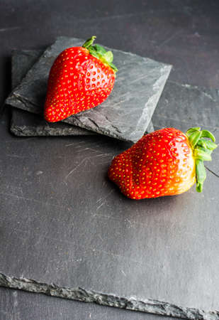 Fresh ripe organic strawberry fruits on dark wooden backgroundの写真素材