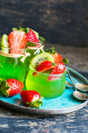 Jelly kiwi and strawberry desset on rustic table with copyspaceの写真素材