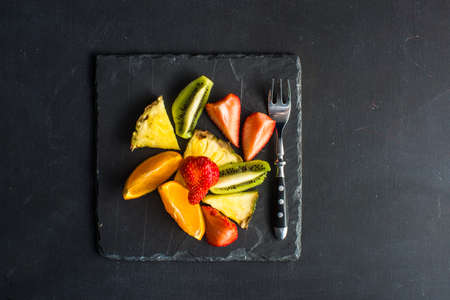 Organic fruit dessert with fresh pineapple, kiwi, orange and strawberries