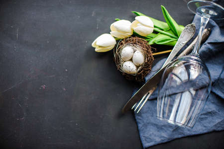 Easter frame with tulips and easter eggs on dark background