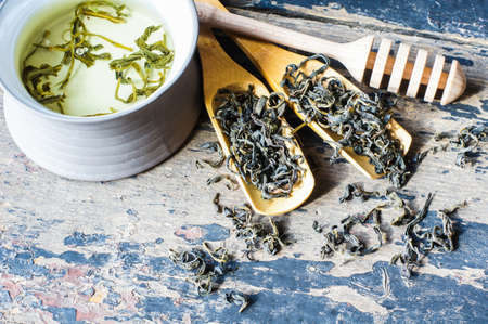 Green tea and leaves on rustic wooden tableの写真素材