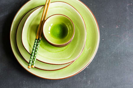 Stacked plates and bowls on wooden bakcgroundの写真素材