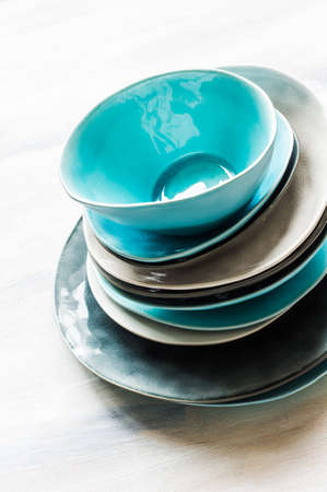 Stacked plates and bowls on wooden bakcgroundの写真素材