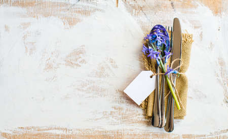 Bouquet of bright blue hyacinth flowers on rustic plate in festive spring table settingの写真素材