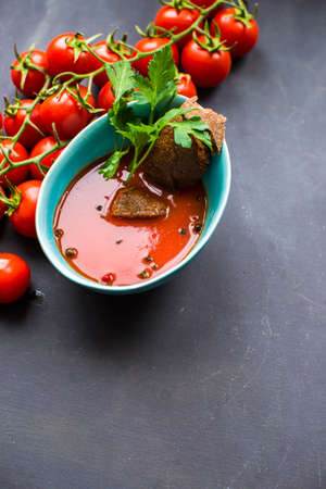 Gazpacho tomato soup and ingredients on dark wooden tableの写真素材