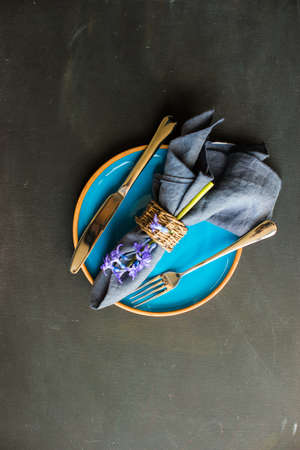 Bouquet of bright blue hyacinth flowers on rustic plate in festive spring table settingの写真素材