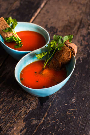 Gazpacho tomato soup and ingredients on dark wooden tableの写真素材