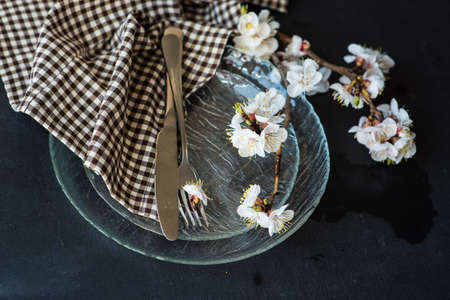 Spring table setting with bright plates and peach blooming on a wooden tableの写真素材