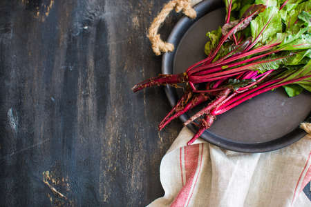 Fresh organic beet with leaves on dark wooden backgroundの写真素材