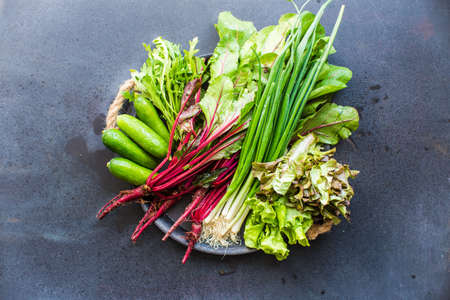 Organic vegetables like a beets, green onion, rukkola, lettuce on dark wooden backgroundの写真素材