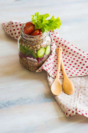 Healthy food in a bottle - buckwheat with fresh organic vegetales as a salad in a vintage bottleの写真素材