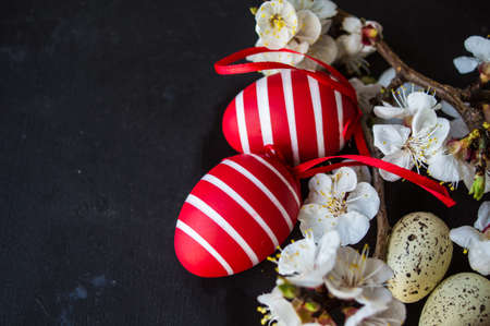 Spring table setting for Easter dinner with bright plates and peach blooming on a wooden tableの写真素材
