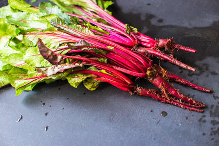 Fresh organic beet with leaves on dark wooden backgroundの写真素材