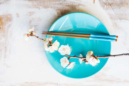 Spring table setting with chopsticks and peach blooming on a wooden tableの写真素材