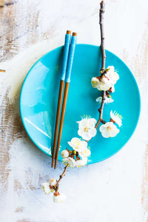 Spring table setting with chopsticks and peach blooming on a wooden tableの写真素材