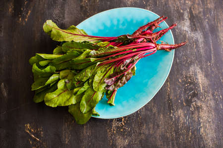 Fresh organic beet with leaves on dark wooden backgroundの写真素材