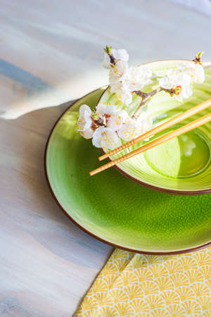 Spring table setting with chopsticks and peach blooming on a wooden tableの写真素材