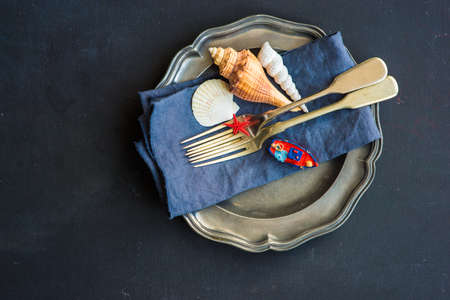Summer vacation marine table setting with rustic plates and silverware on wooden background with copyspaceの写真素材