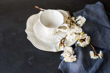 Spring table setting with bright plates and peach blooming on a wooden tableの写真素材