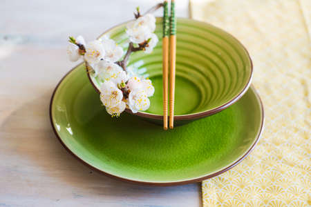 Spring table setting with chopsticks and peach blooming on a wooden tableの写真素材