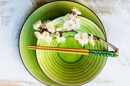Spring table setting with chopsticks and peach blooming on a wooden tableの写真素材