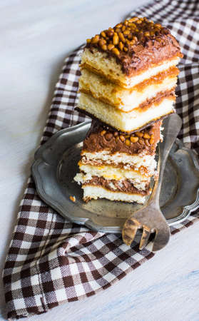 Vanilla and chocolate biscuit cake on rustic wooden table