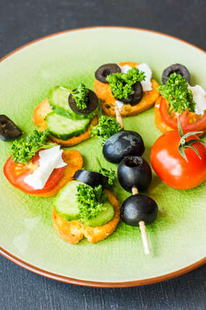 Bruschetta with cheese and vegetables on dark wooden tableの写真素材
