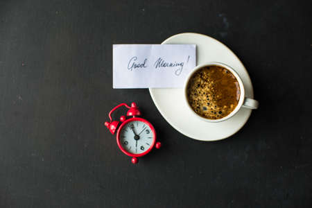 Mug with black coffee, coffee beans, milk and sugar on dark wooden tableの写真素材