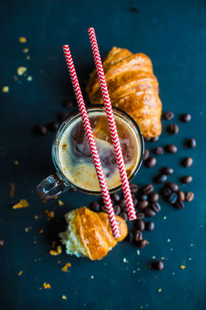 Cup of coffee with croissanton the old wooden table