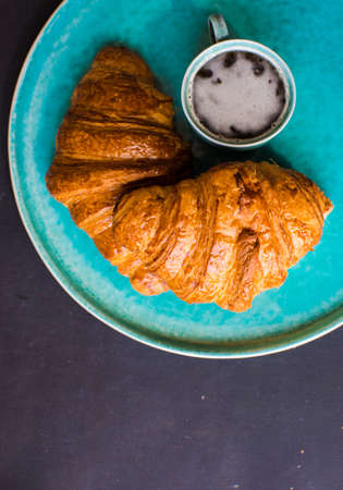 Fresh homemade french croissant on dark wooden tableの写真素材