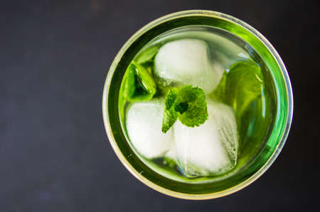 Summer drink glass of water with ice on dark backgroundの写真素材