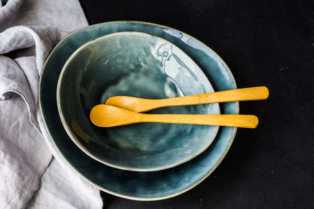 Empty rustic bowl and vintage wooden spoons on old wooden tableの写真素材