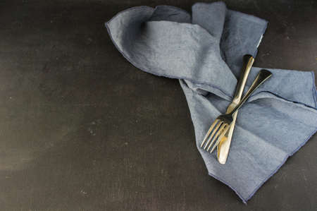 Table setting with napkin and silverware on dark wooden backgroundの写真素材