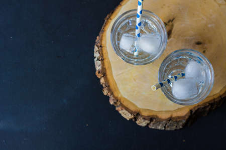 Summer drink glass of water with ice on dark backgroundの写真素材