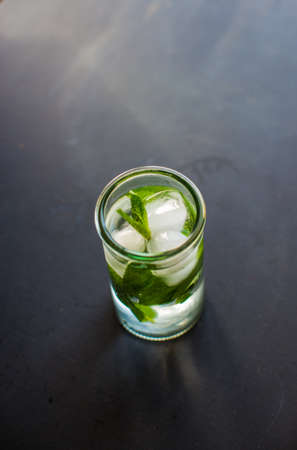 Summer drink glass of water with ice on dark backgroundの写真素材