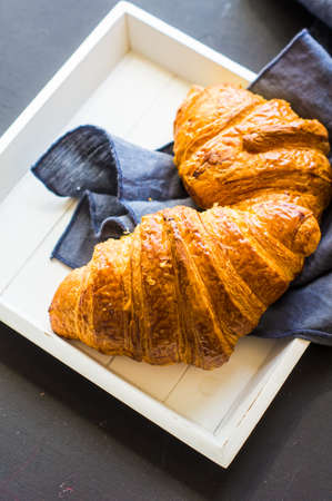 Fresh homemade french croissant on dark wooden tableの写真素材