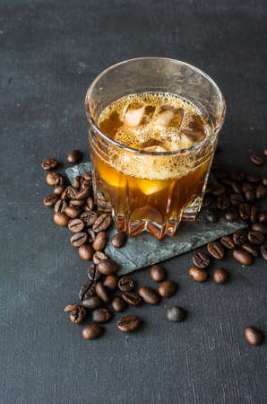 Alcohol coffee liqueur with coffee beans on dark wooden tableの写真素材