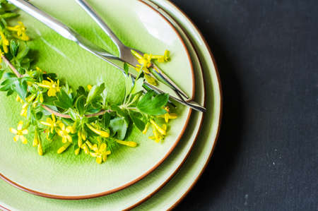 Spring table setting with blooming tree branch with  yellow flowers