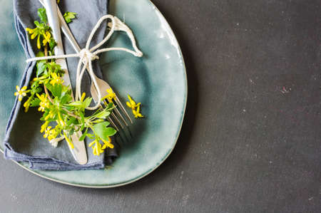Spring table setting with blooming tree branch with  yellow flowers