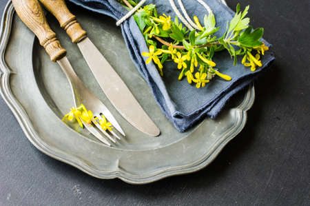 Spring table setting with blooming tree branch with  yellow flowers