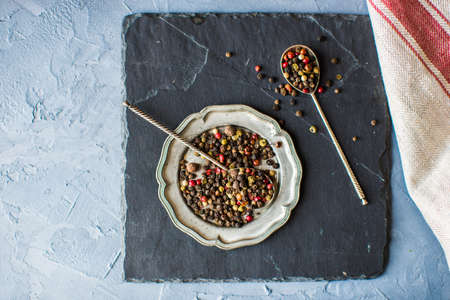 Peper grain spice on vintage plate on concrete backgroundの写真素材