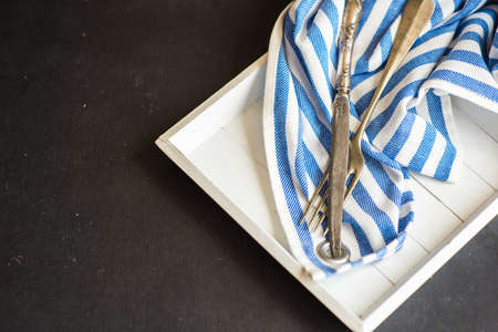 Summer marine themed table setting with stripped napkin and seashells on dark rustic tableの写真素材